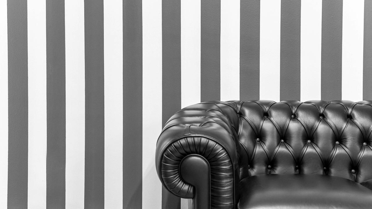 La parete a righe e il divano Chesterfield del salone